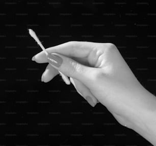 2nd May 1961:  A manicured female hand holding a cotton bud, designed for cleaning the ear.  (Photo by Chaloner Woods/Getty Images)