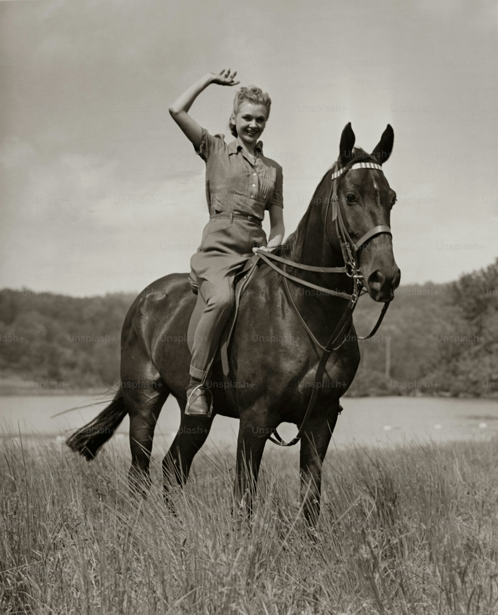 UNITED STATES - CIRCA 1950s:  Woman waving from horseback.