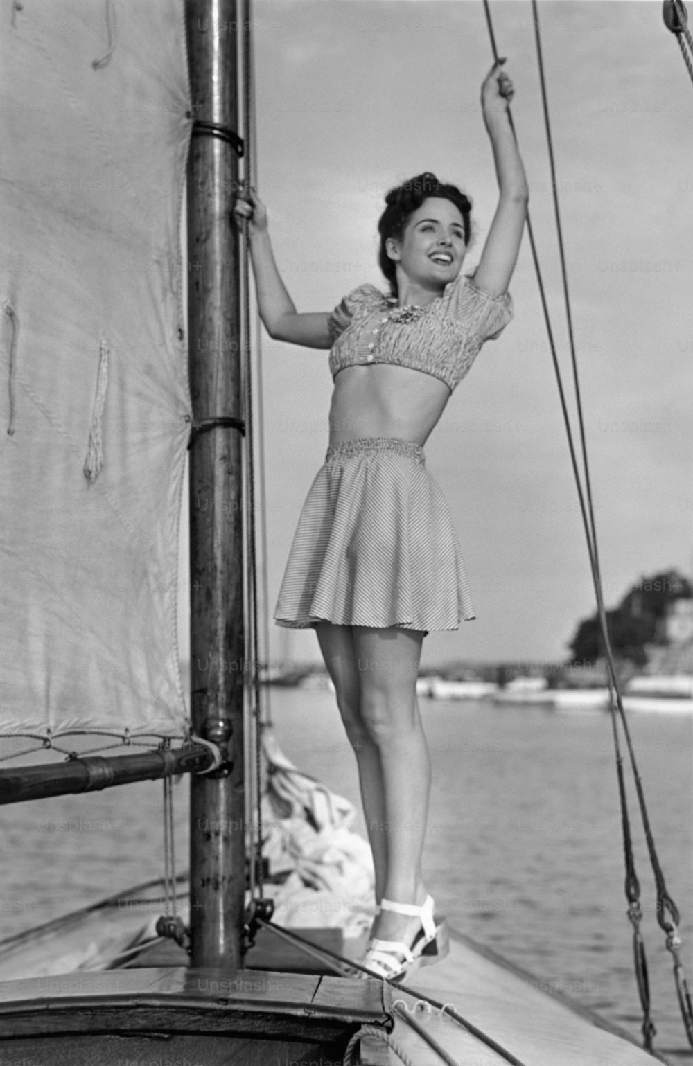UNITED STATES - CIRCA 1950s:  Young woman on sailboat.