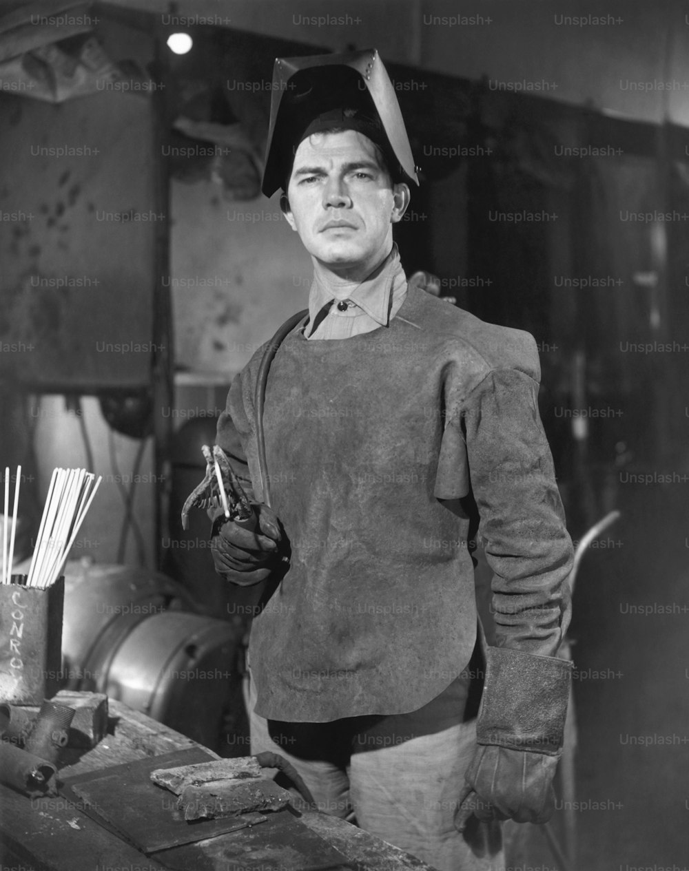 UNITED STATES - CIRCA 1950s:  Man in welding gear in WW II defense plant.