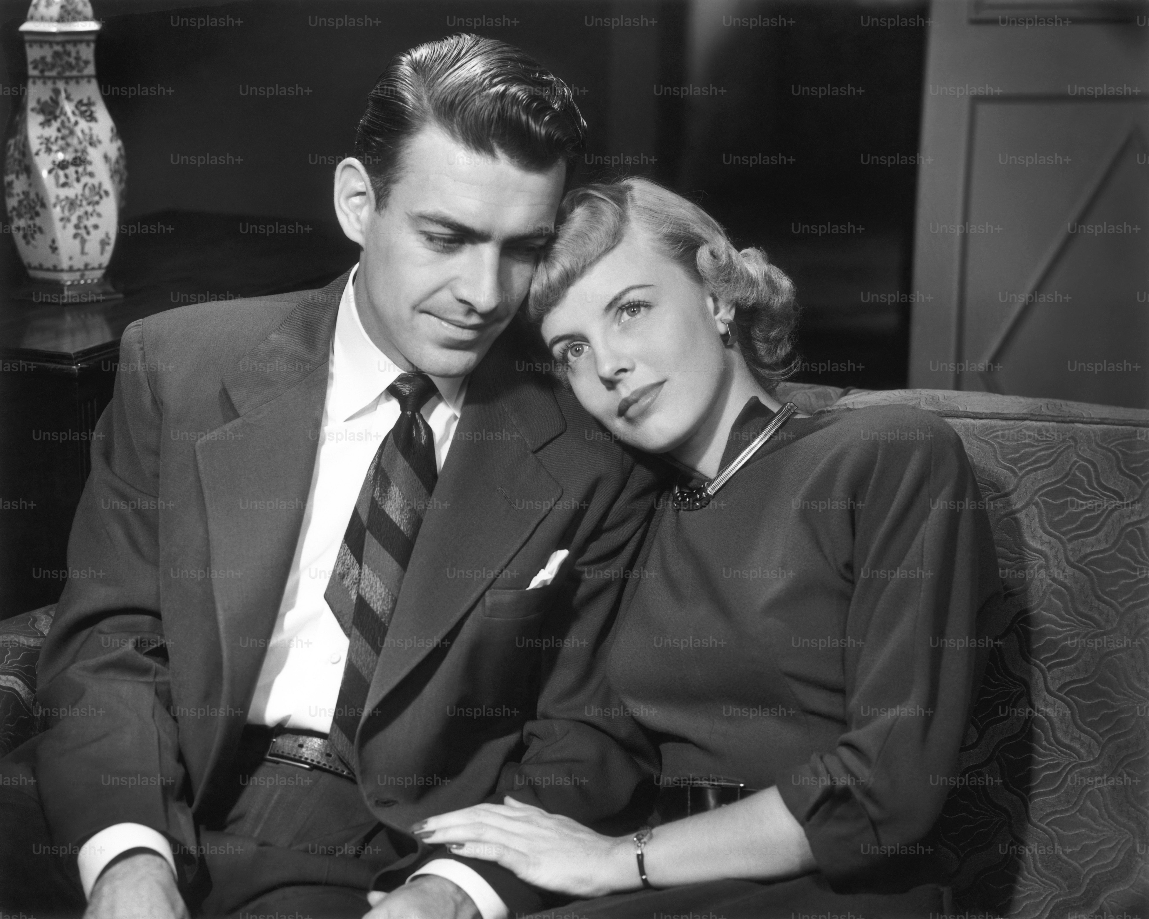 UNITED STATES - CIRCA 1950s:  Couple snuggling on couch.