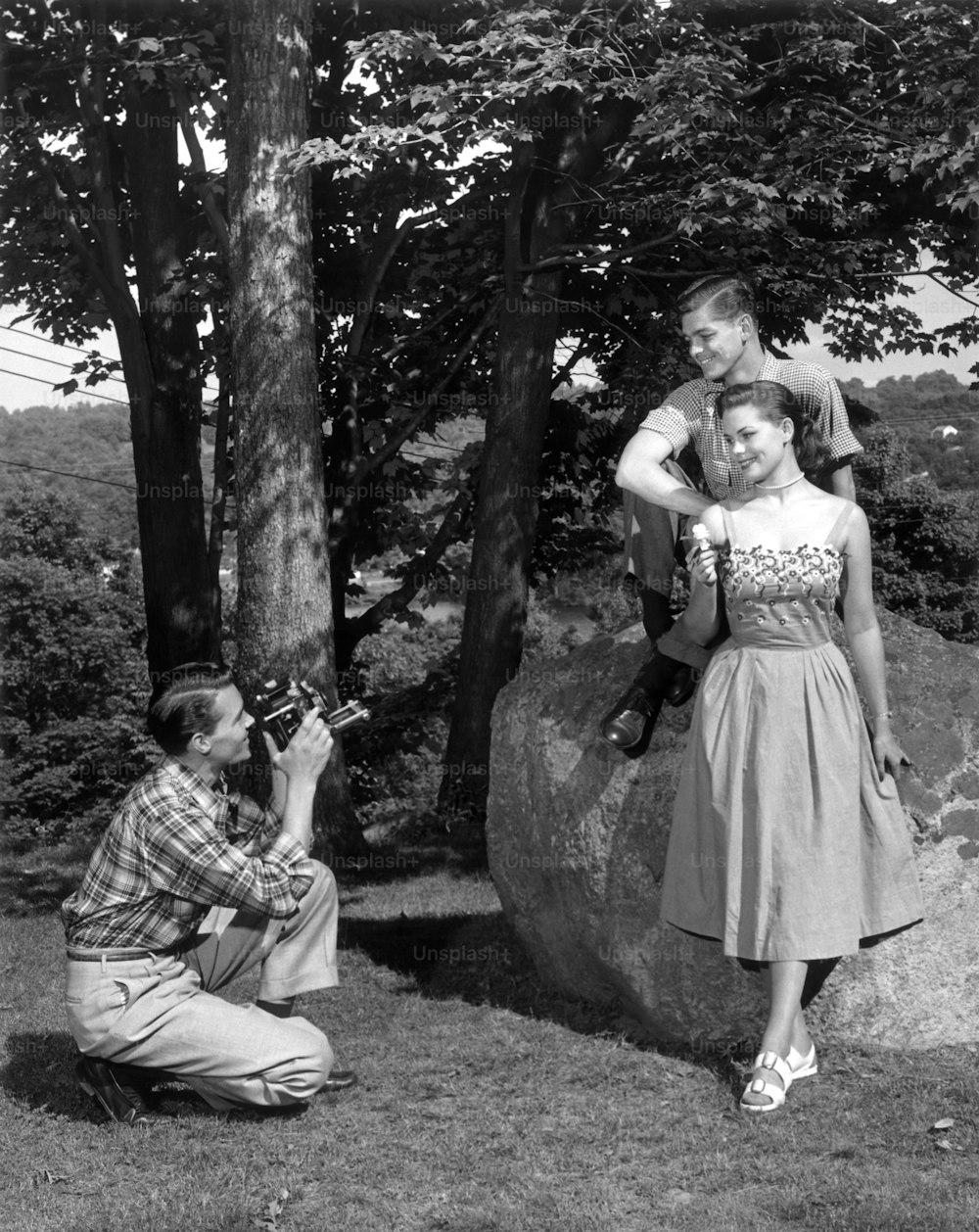 미국 - 1950년대경: 휴가 중인 커플의 사진을 찍는 친구.