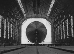 El dirigible alemán LZ 127 Graf Zeppelin entra en uno de los hangares gigantes de dirigibles, Frankfurt, Alemania, el 11 de mayo de 1936. El Graf Zeppelin es el primer avión en utilizar el hangar en las instalaciones portuarias de dirigibles recién construidas. (Foto de Stiehr/Archive Photos/Getty Images)