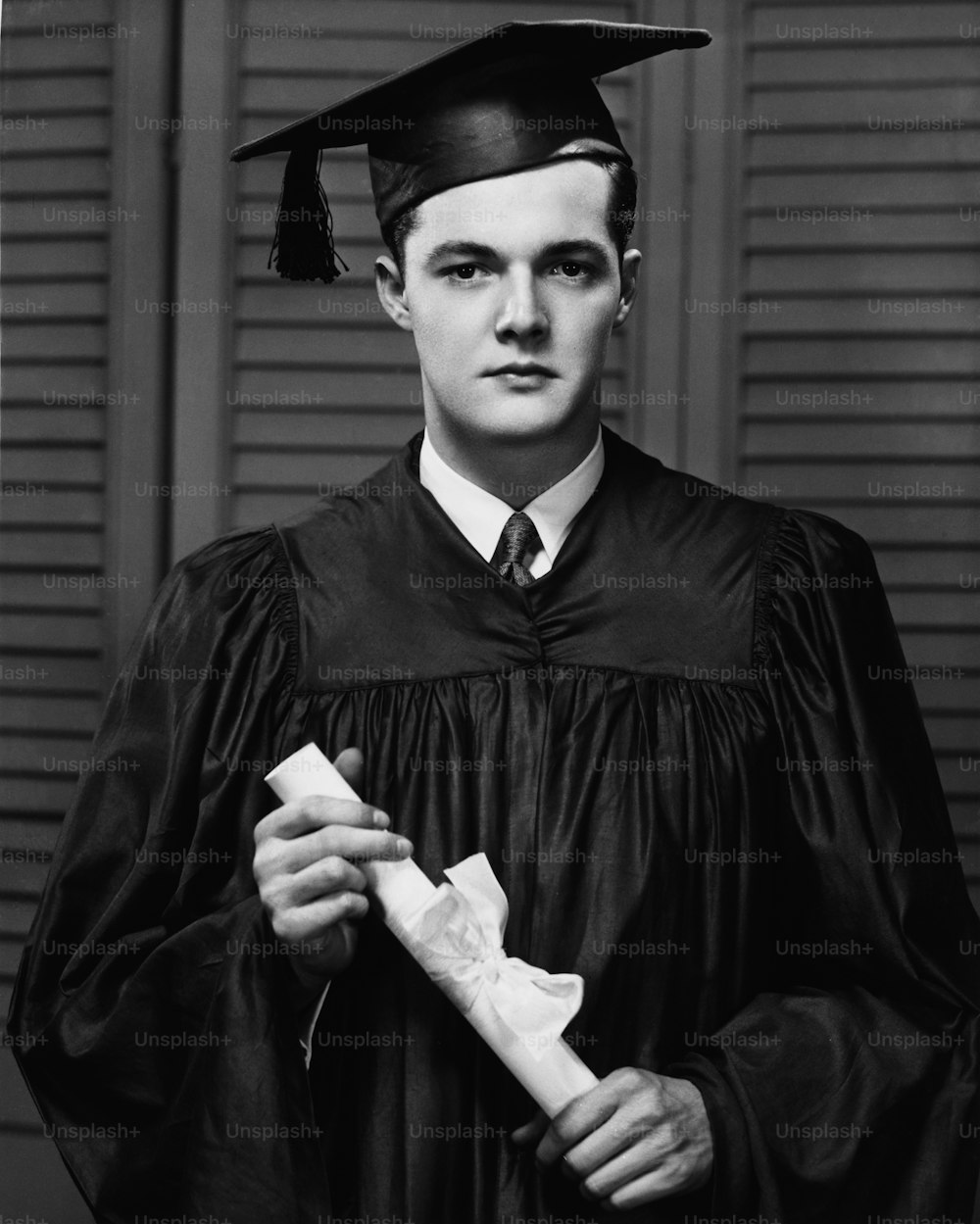 A young man in his graduation gown and mortarboard, holding his diploma, circa 1940.  (Photo by George Marks/Retrofile/Getty Images)