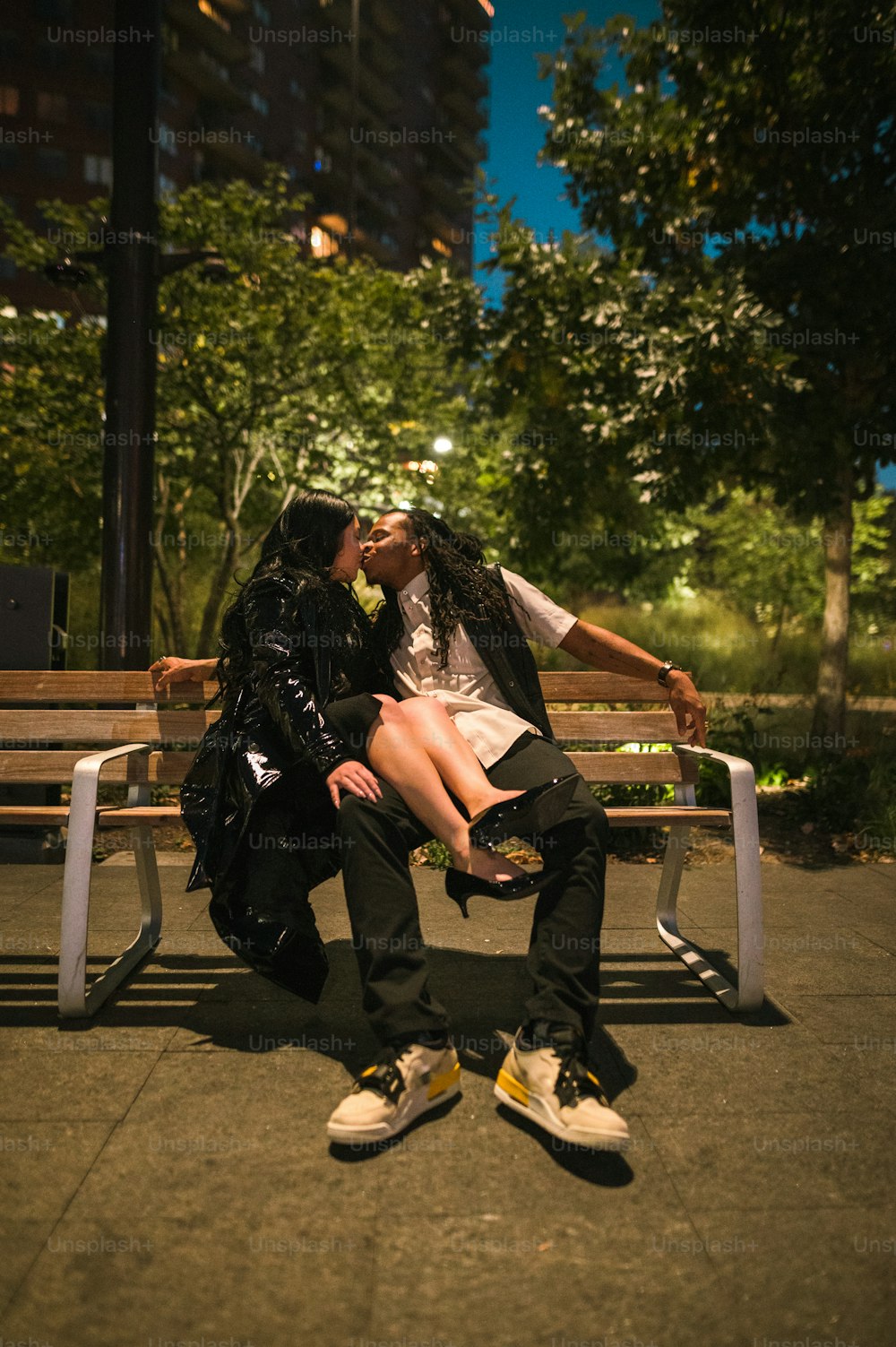 a man and a woman kissing on a bench