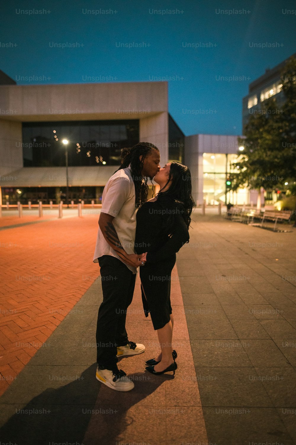 Un uomo e una donna che si baciano su uno skateboard