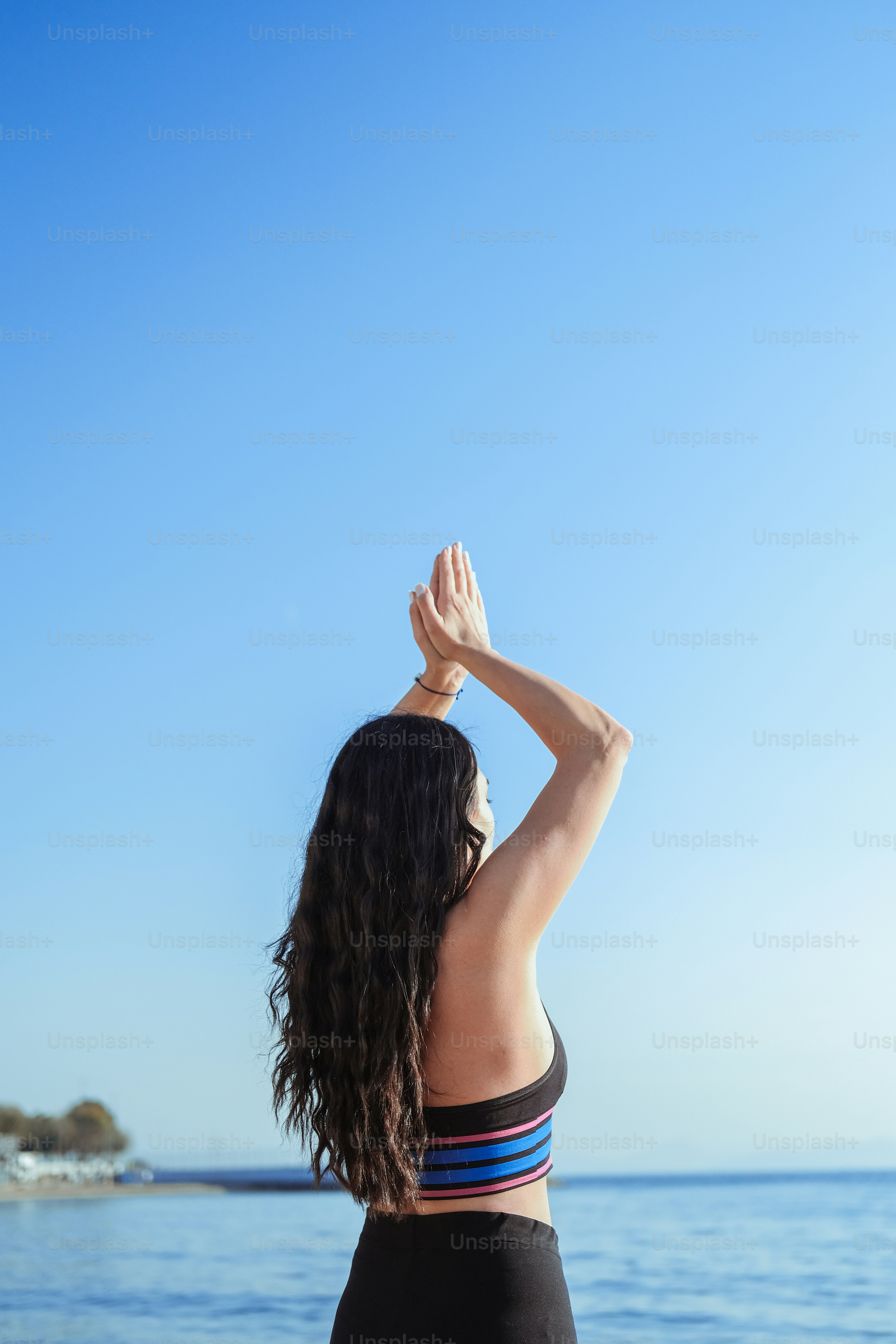 a woman standing on a beach looking at the ocean