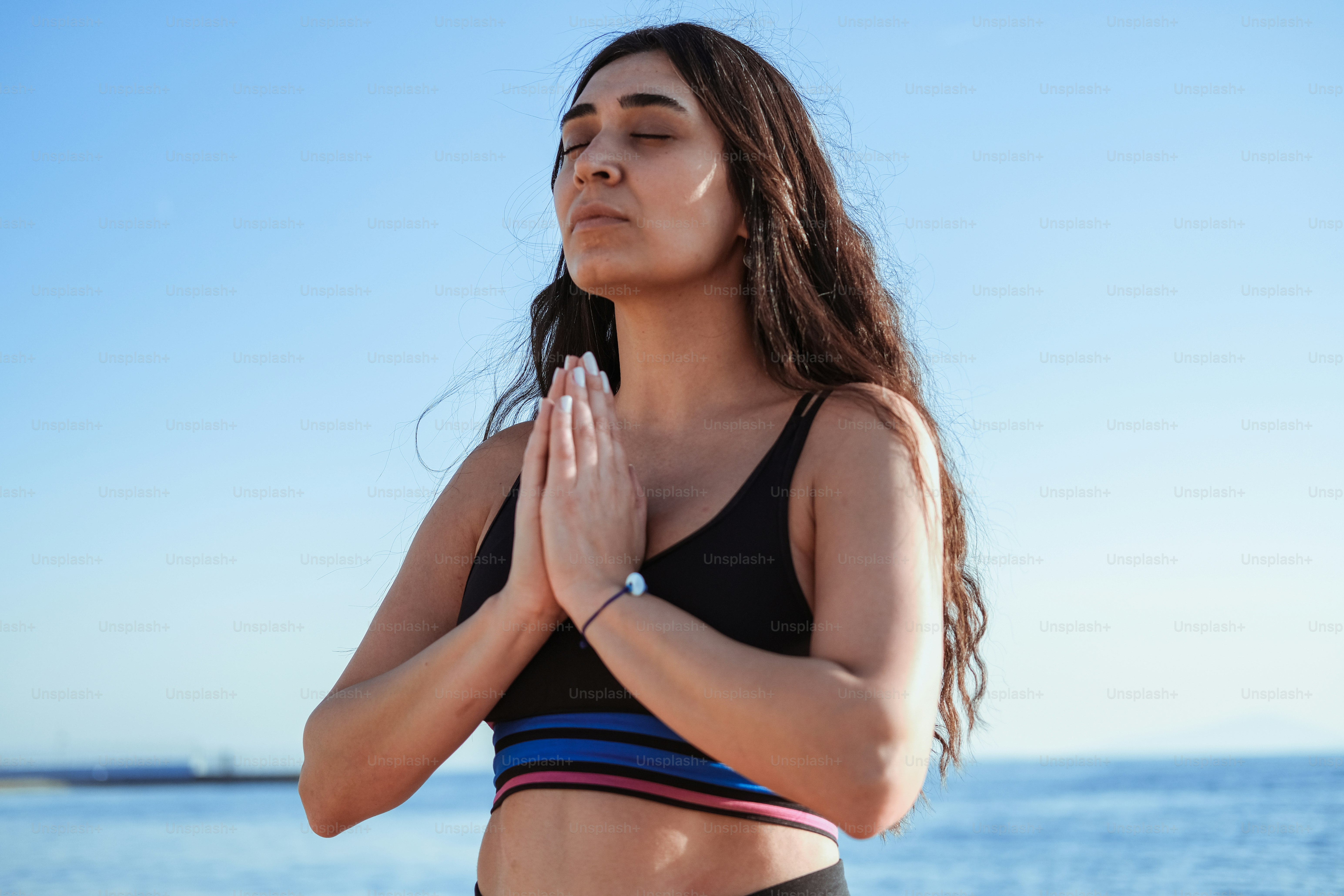a woman standing in front of a body of water