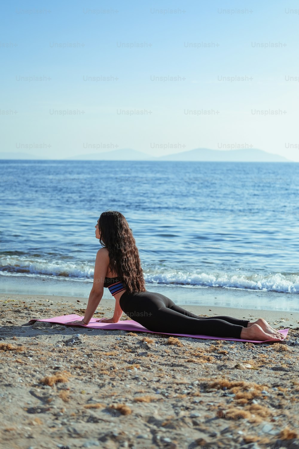 A woman doing a yoga pose on a beach photo – Pilates Image on Unsplash