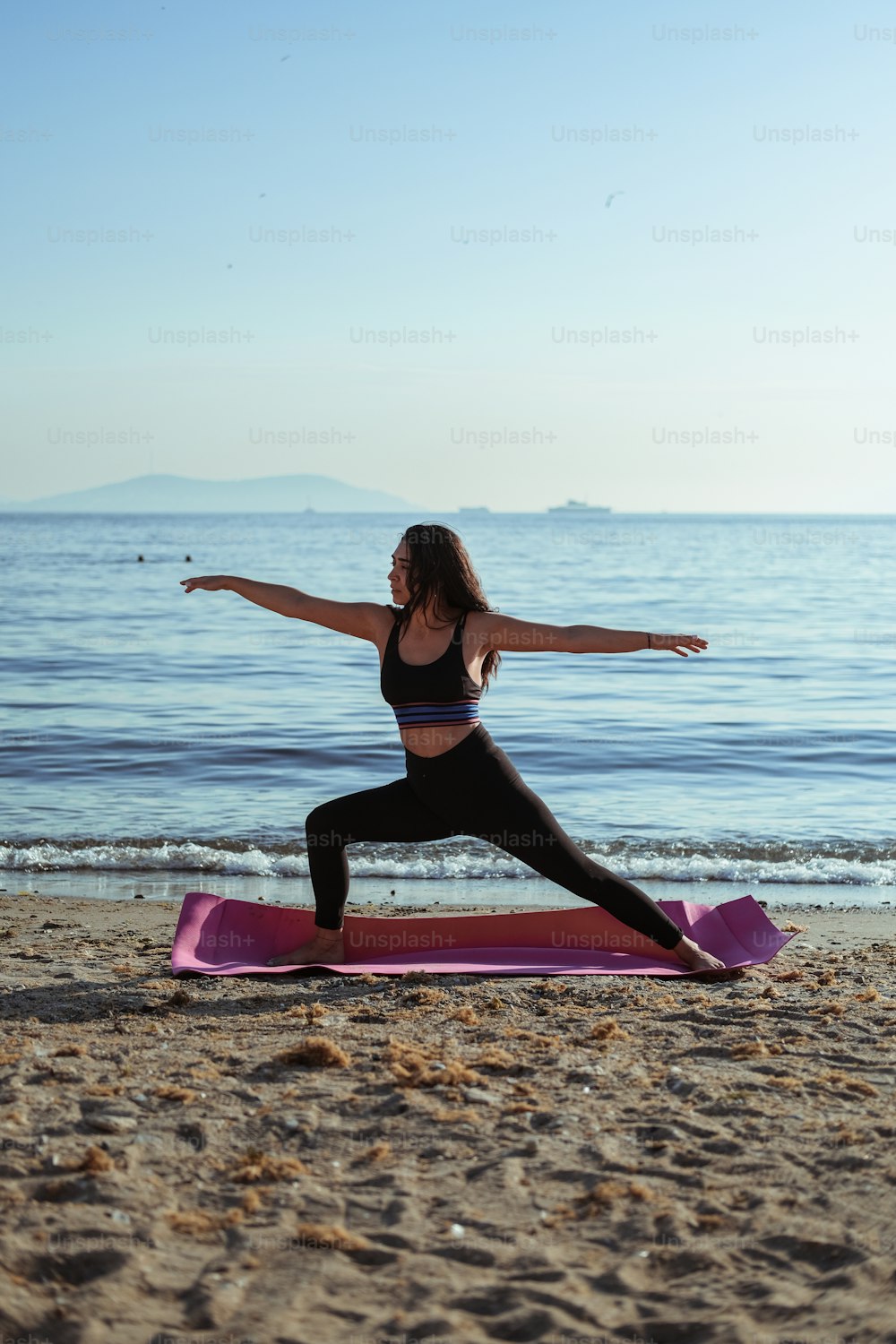 A woman doing a yoga pose on a beach photo – Pilates Image on Unsplash