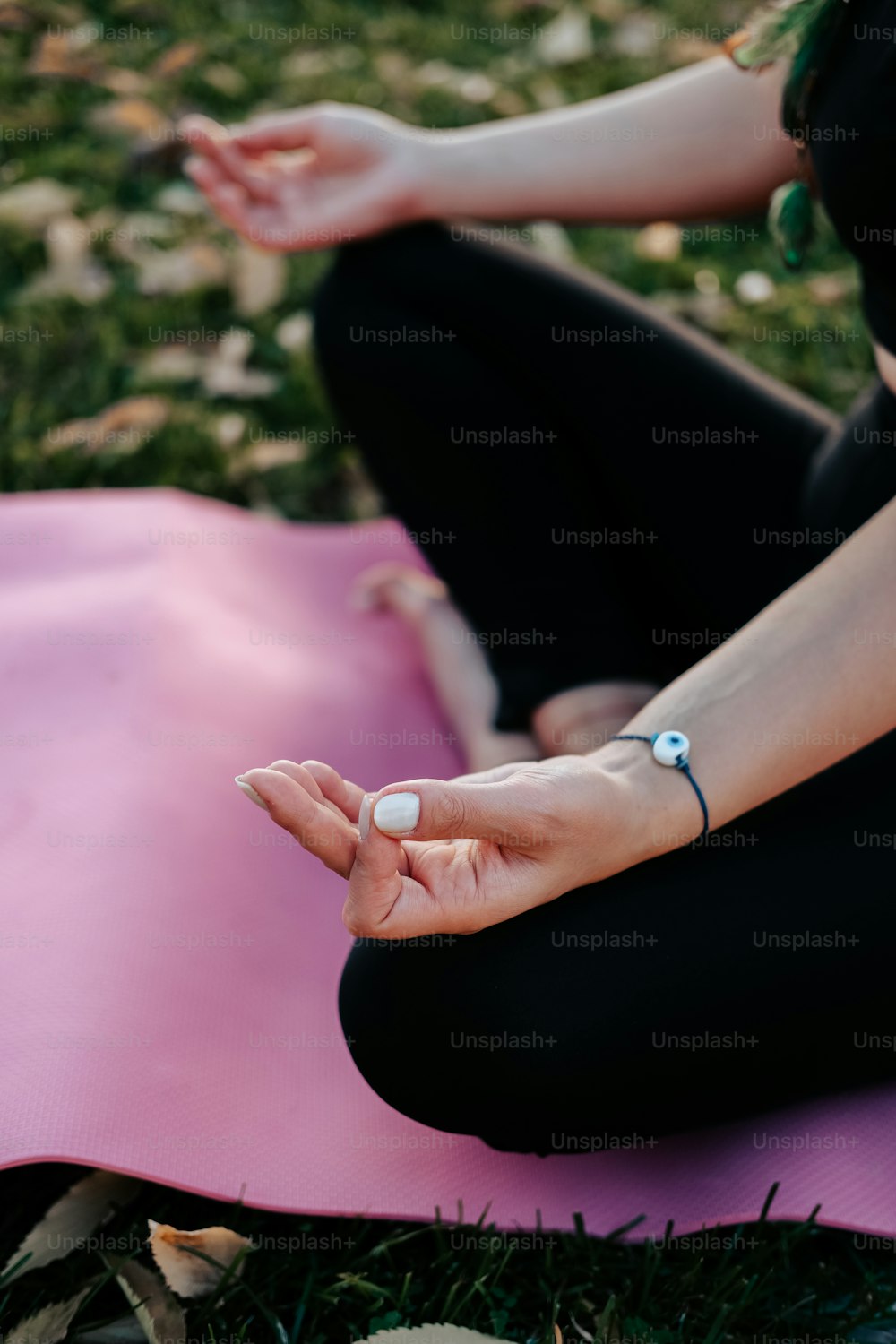 uma mulher sentada em um tapete de ioga fazendo yoga