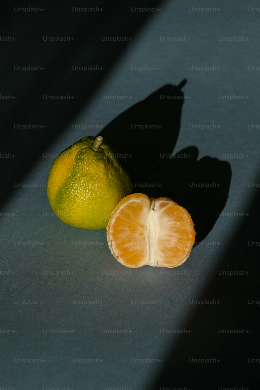 uma laranja cortada ao meio ao lado de um limão