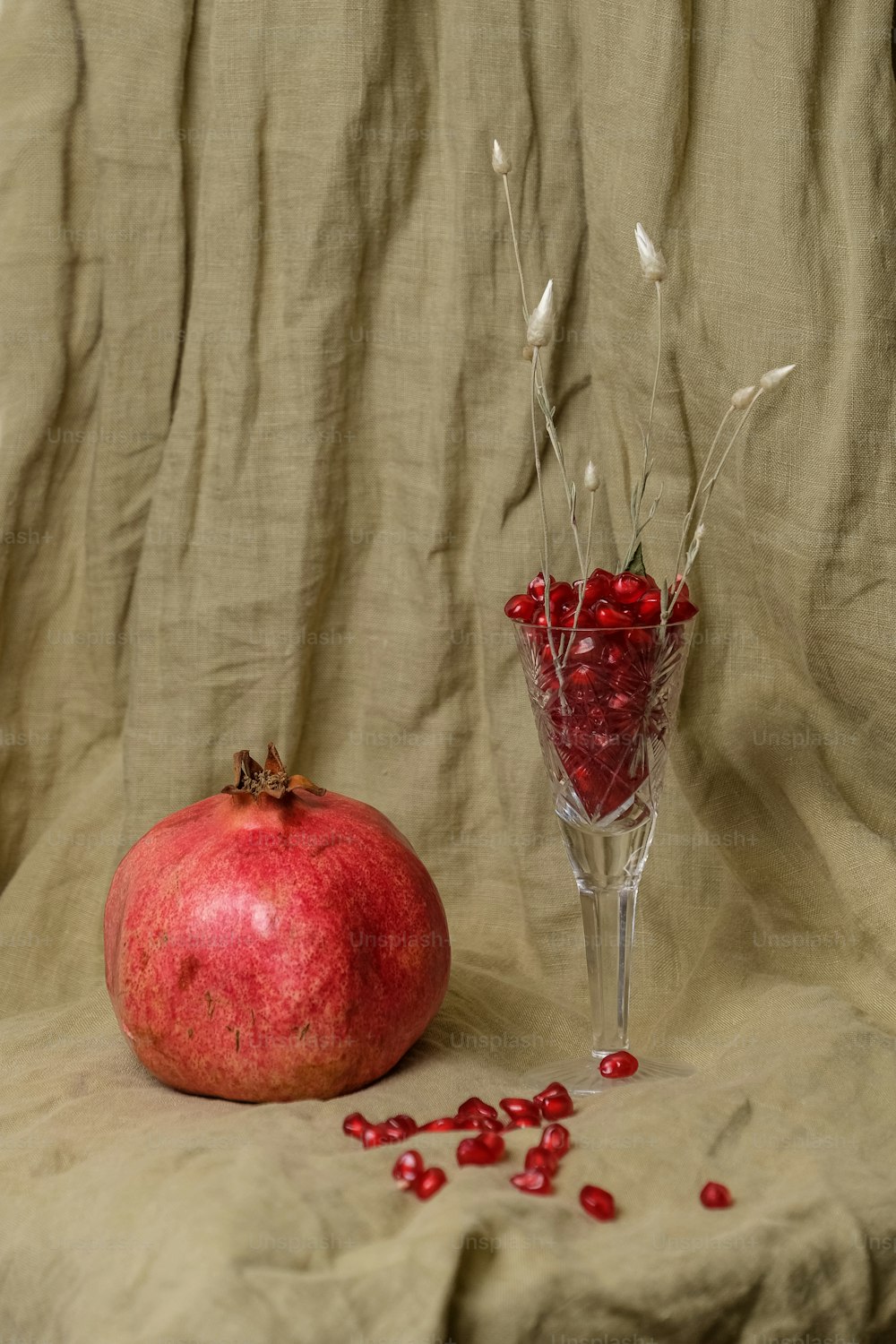 a pomegranate sitting next to a glass vase filled with pomegra