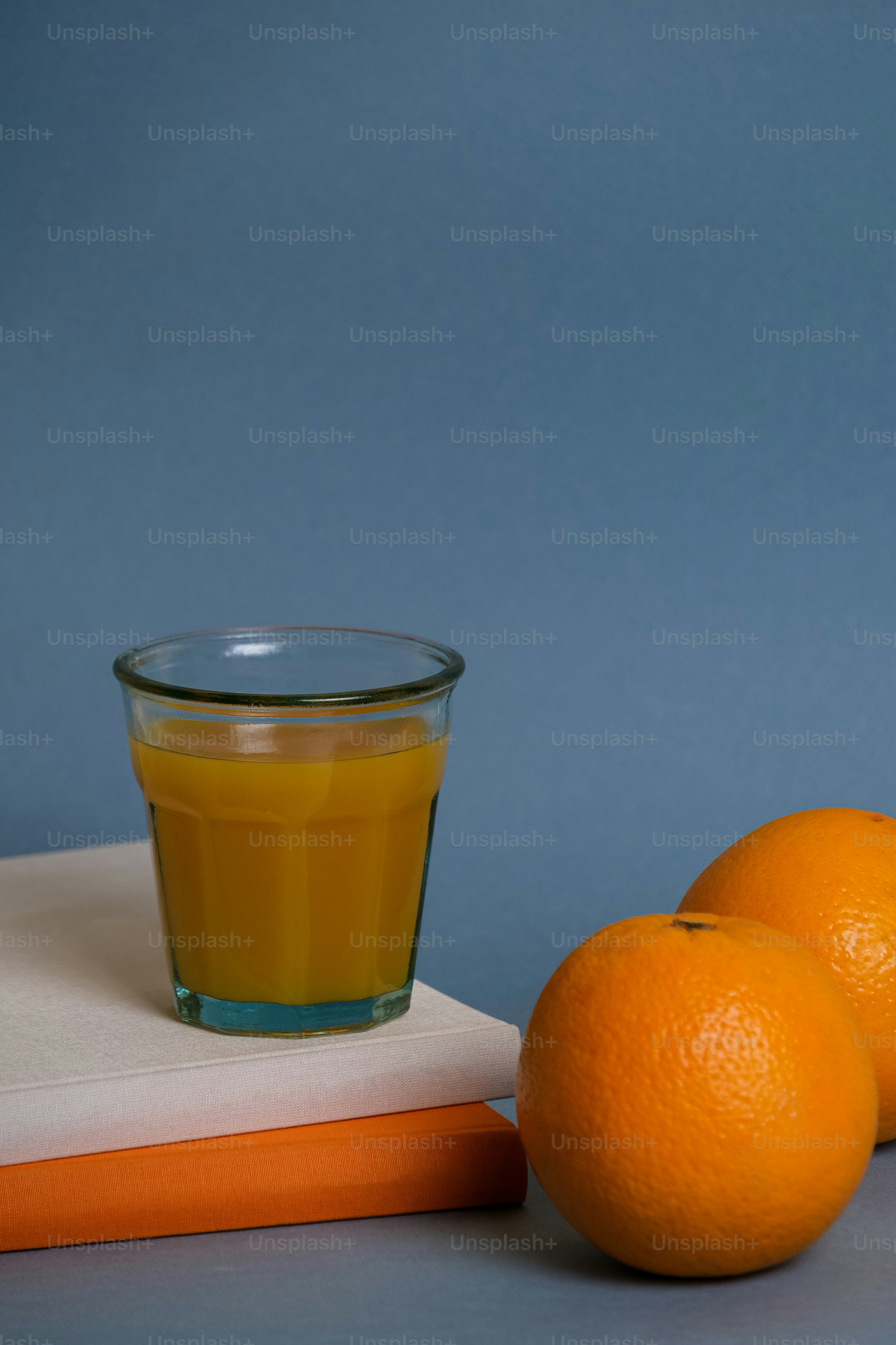 un verre de jus d’orange à côté de trois oranges