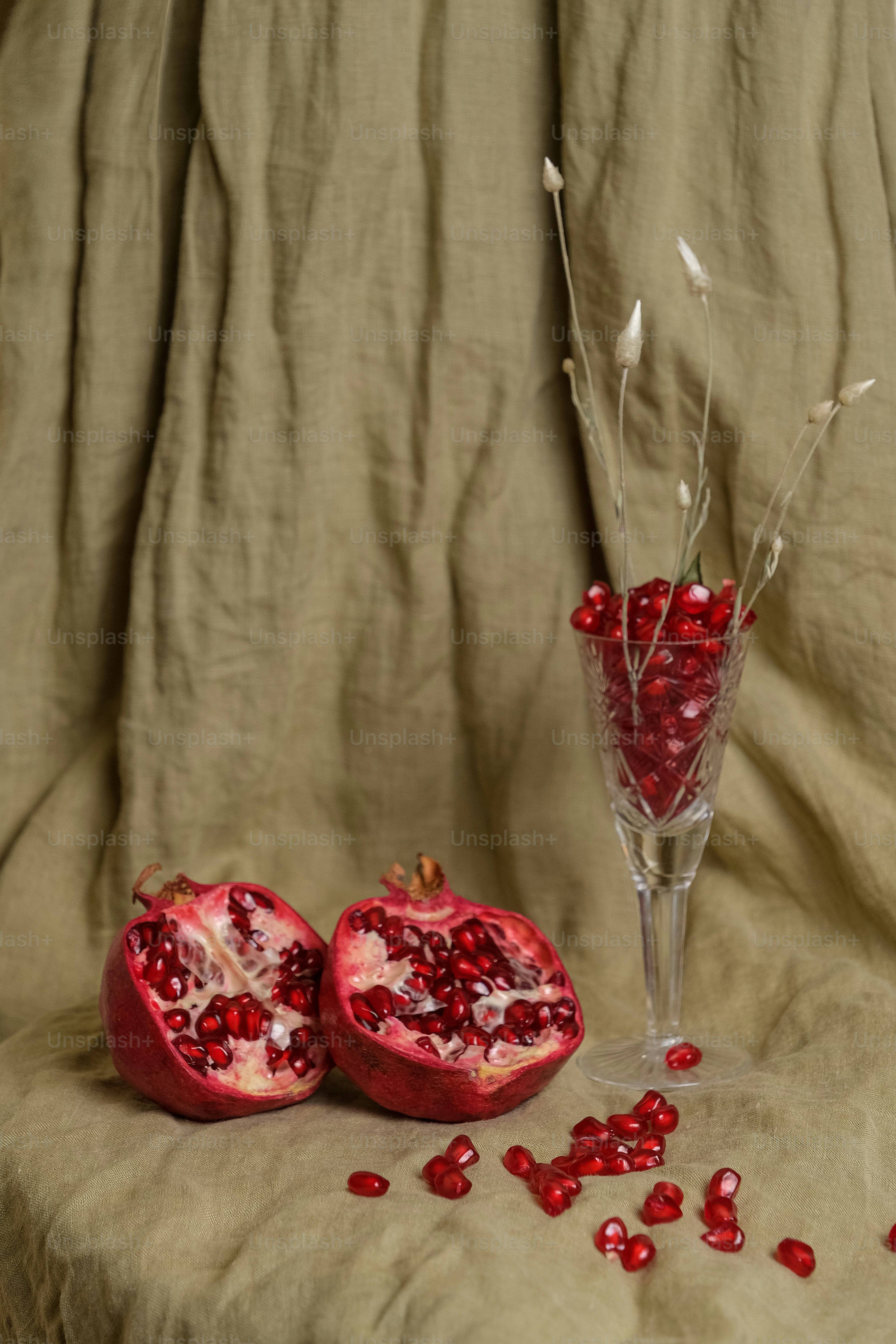 a pomegranate sitting on a table next to a wine glass