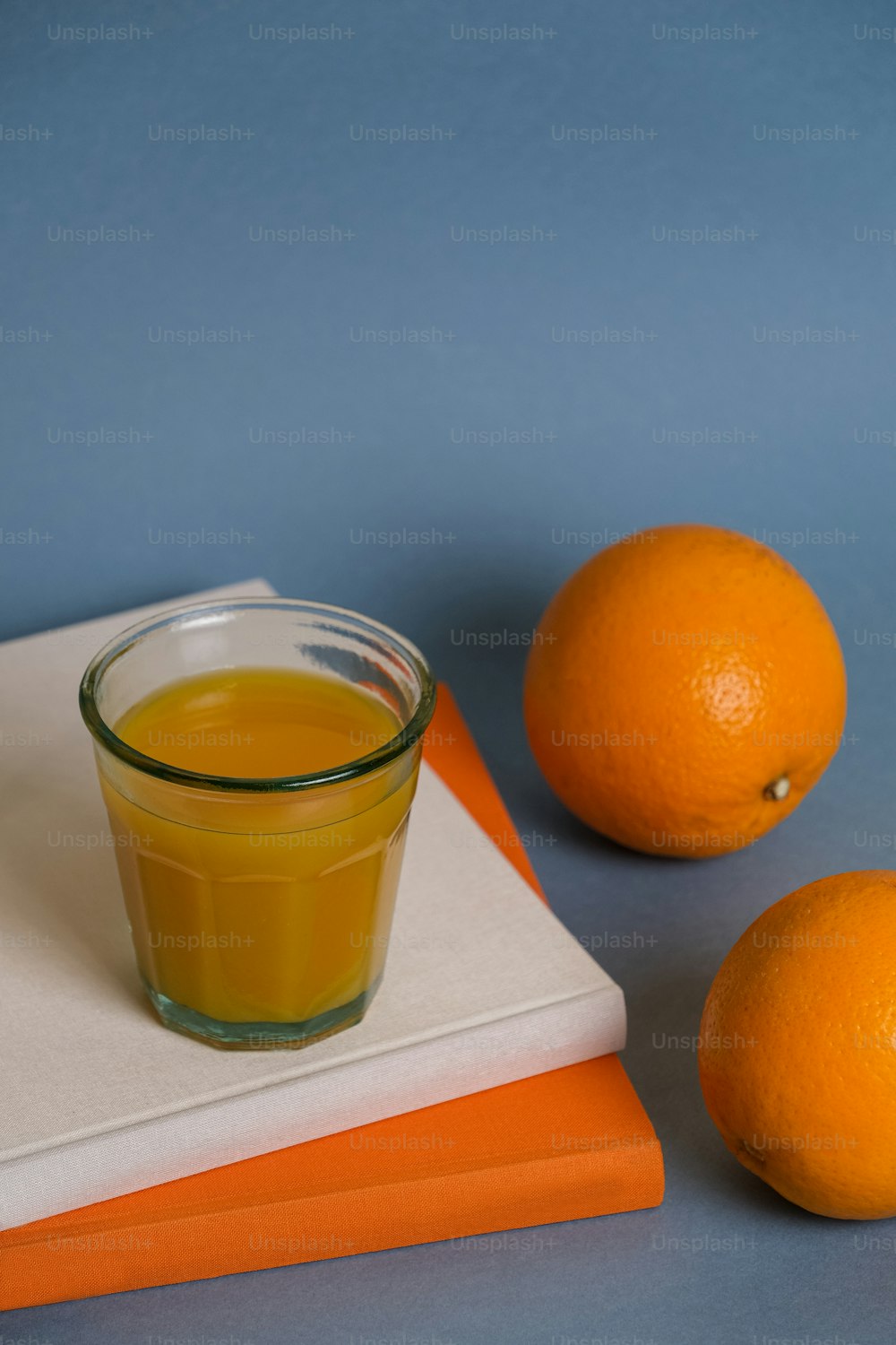 오렌지 두 개 옆에 오렌지 주스 한 잔