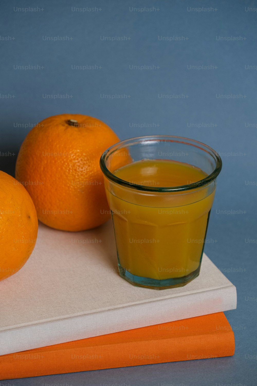 오렌지 두 개 옆에 오렌지 주스 한 잔