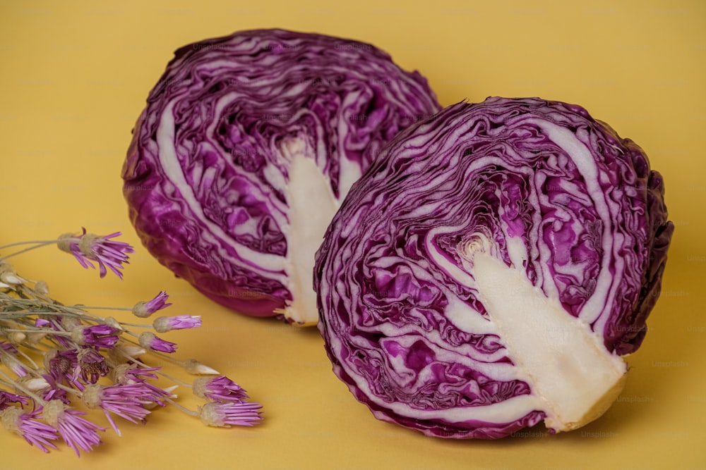 two purple cabbages cut in half on a yellow surface