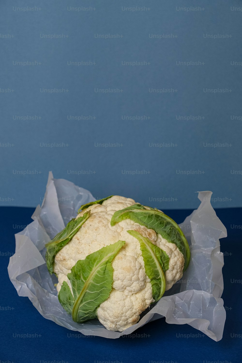 a head of cauliflower on a blue surface