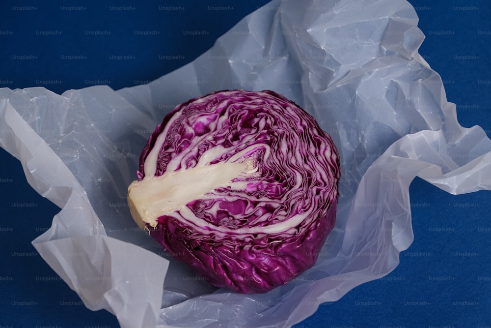 a red cabbage sitting on top of a piece of paper