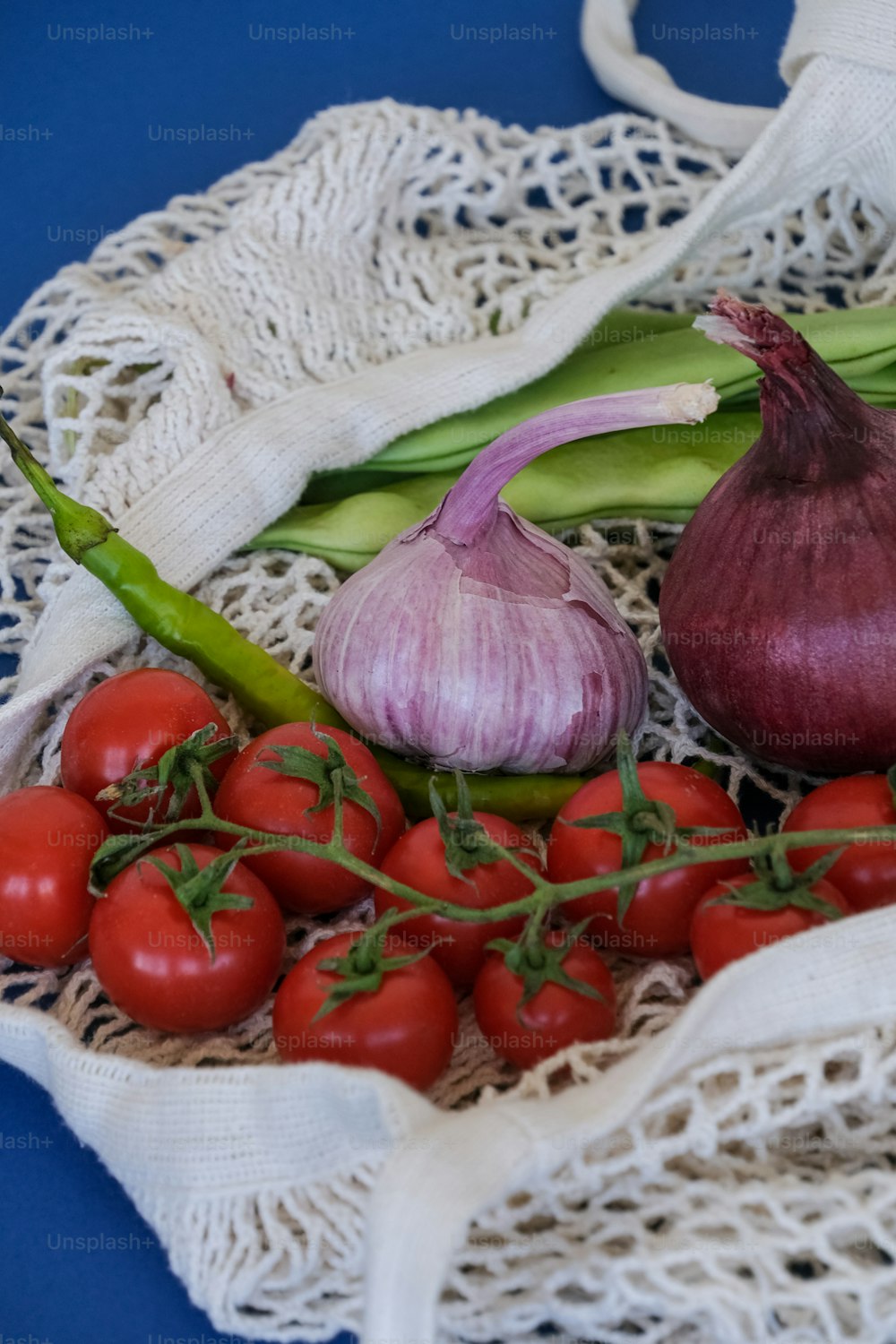 un bouquet de tomates, d’oignons et d’ail sur une table