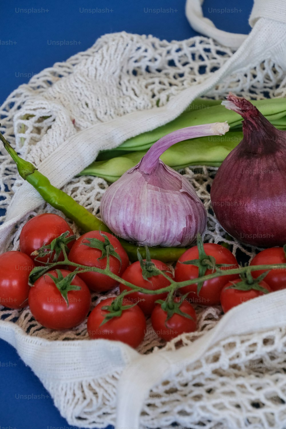 um cacho de tomates, cebola e alho sobre uma mesa