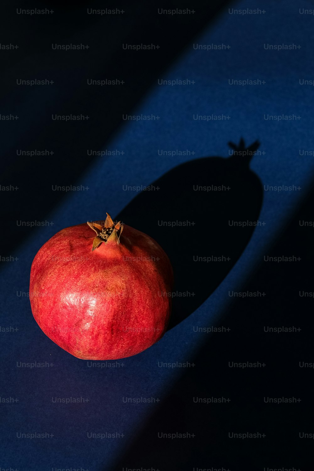 a red apple sitting on top of a blue surface