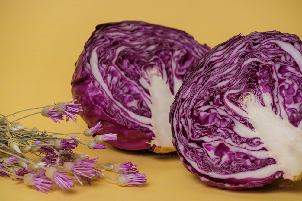 two halves of red cabbage sitting on a yellow surface