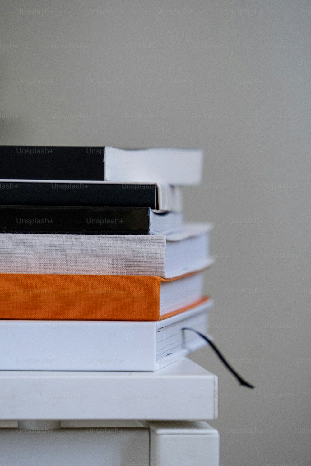 Una pila de libros encima de una mesa blanca