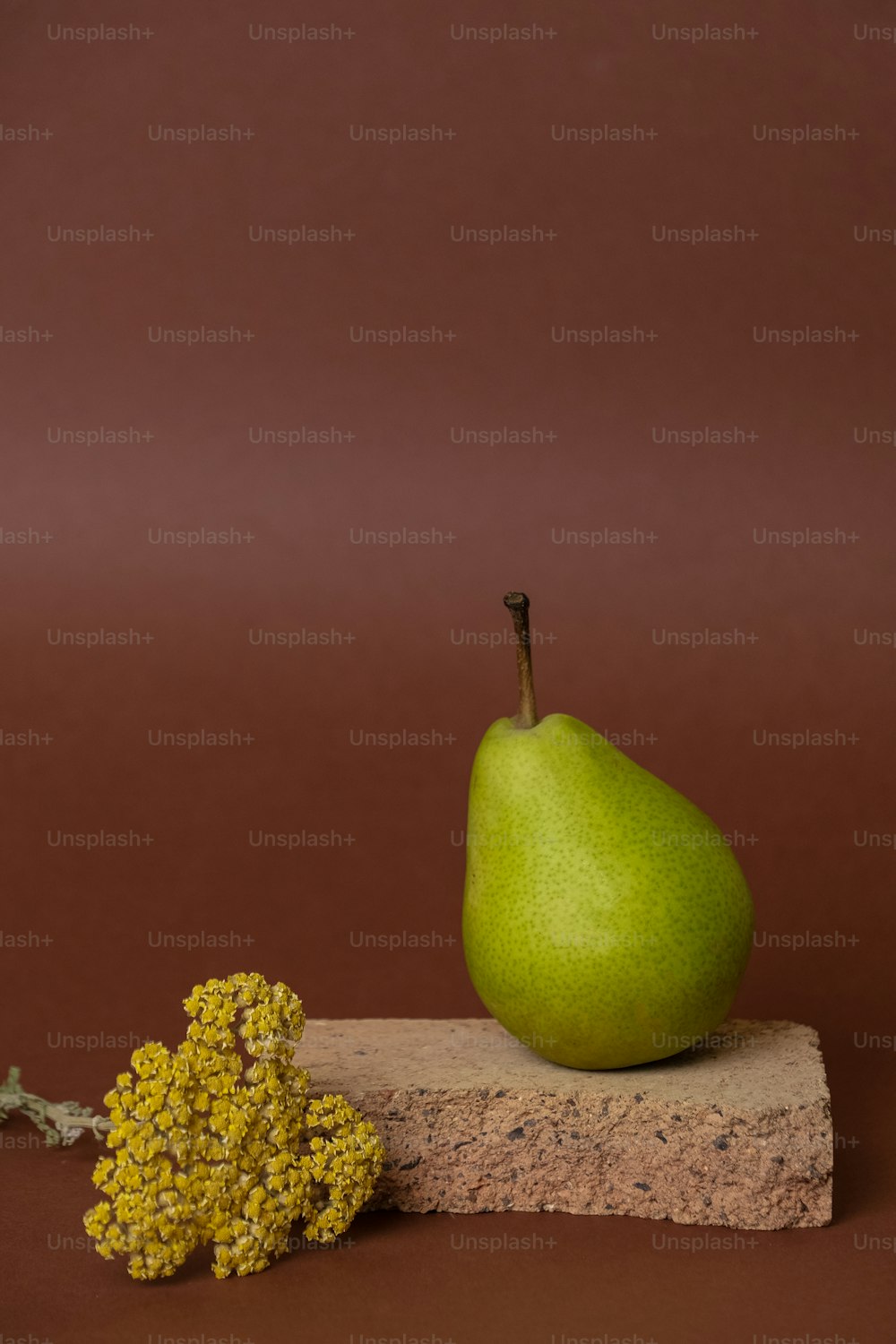 a green pear sitting on top of a piece of wood