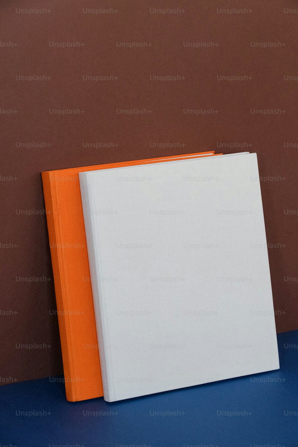 파란색 테이블 위에 놓인 주황색과 흰색의 책