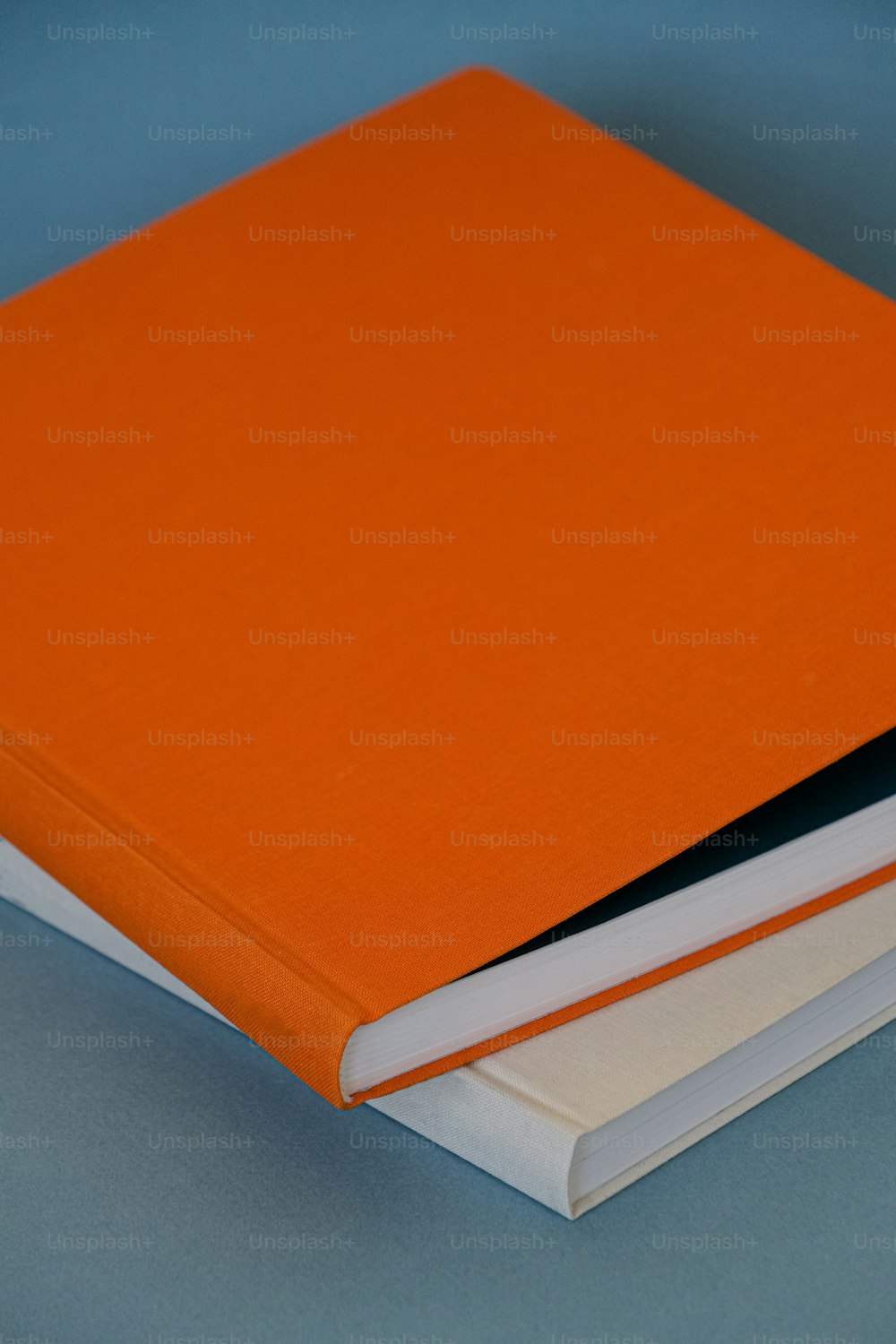 Un livre orange posé sur une table bleue