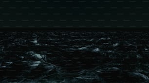 Une photo en noir et blanc de l’océan la nuit
