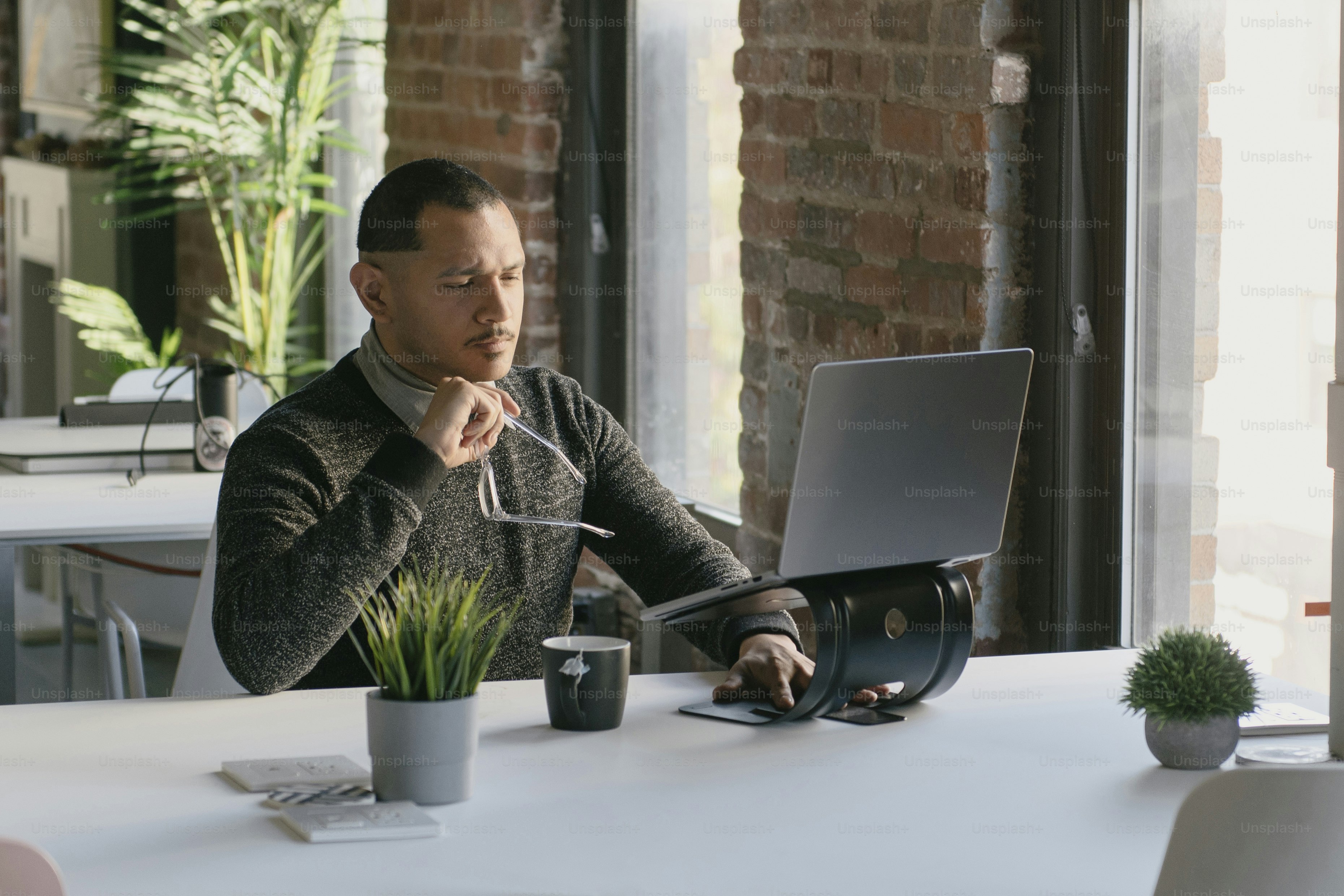 Un hombre sentado en una mesa usando una computadora portátil