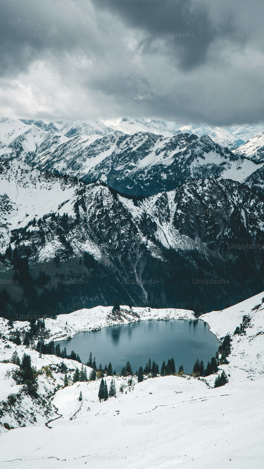 a snow covered mountain with a lake in the middle