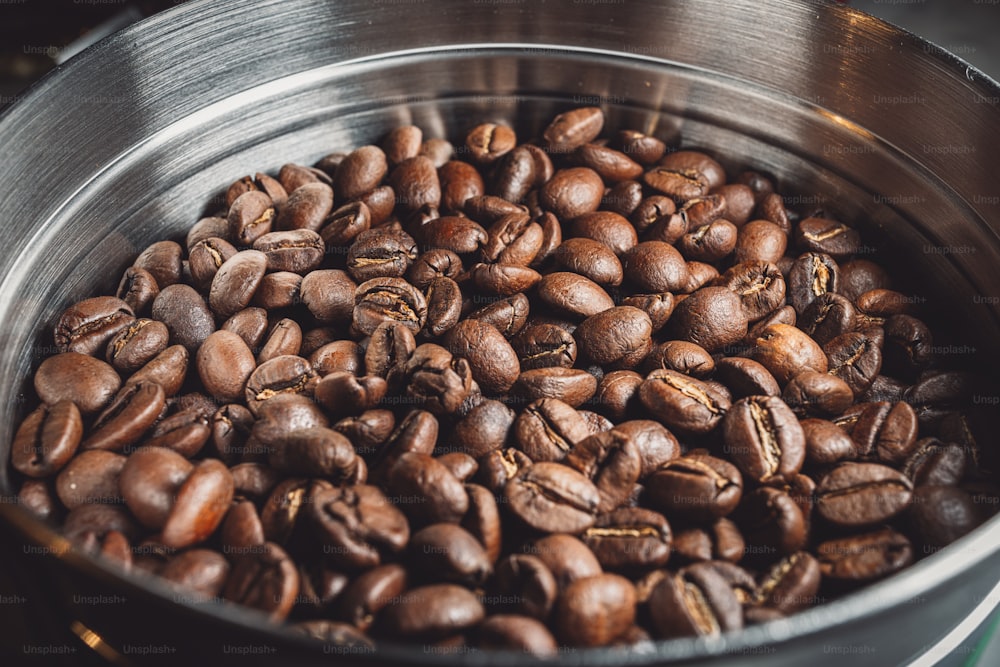 a metal bowl filled with lots of coffee beans