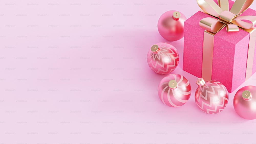 Una caja de regalo rosa con un lazo y adornos a su alrededor