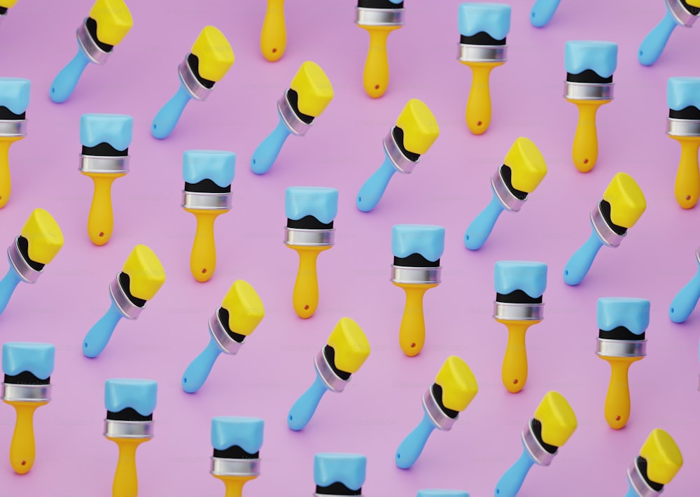 a group of paint rollers on a pink background
