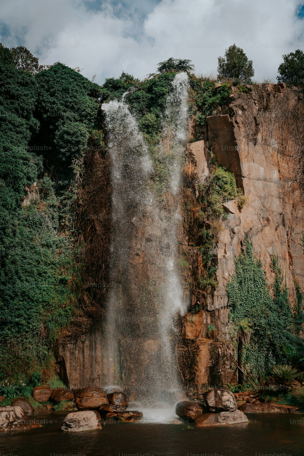 a large waterfall in the middle of a body of water