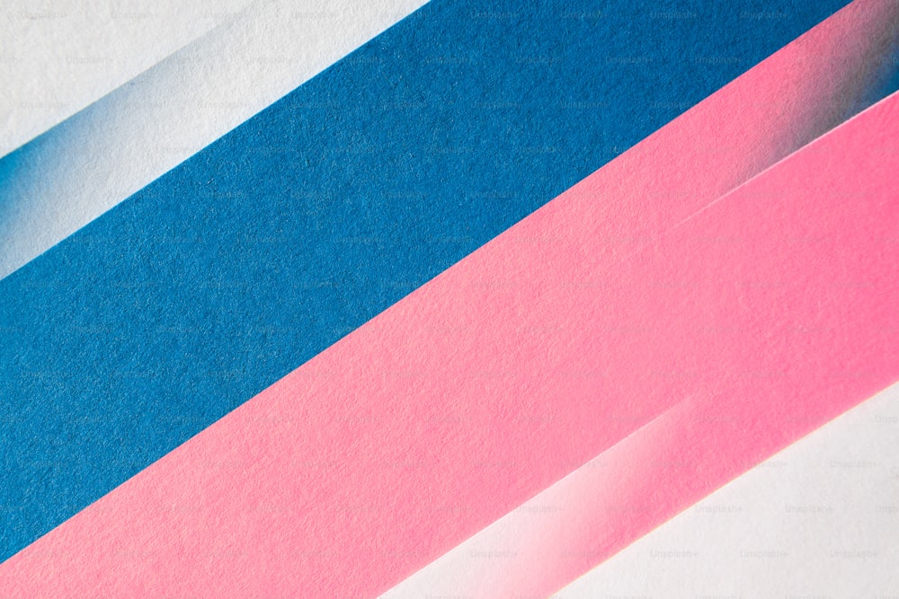 Un primer plano de un pedazo de papel con tiras rosas y azules