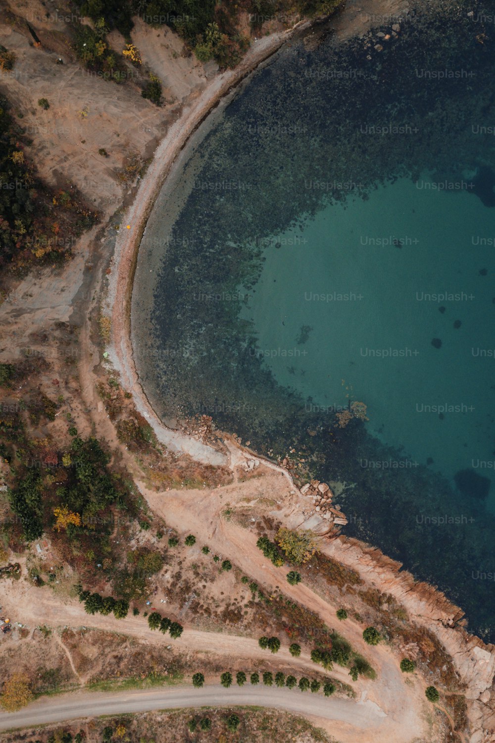 an aerial view of a road near a body of water