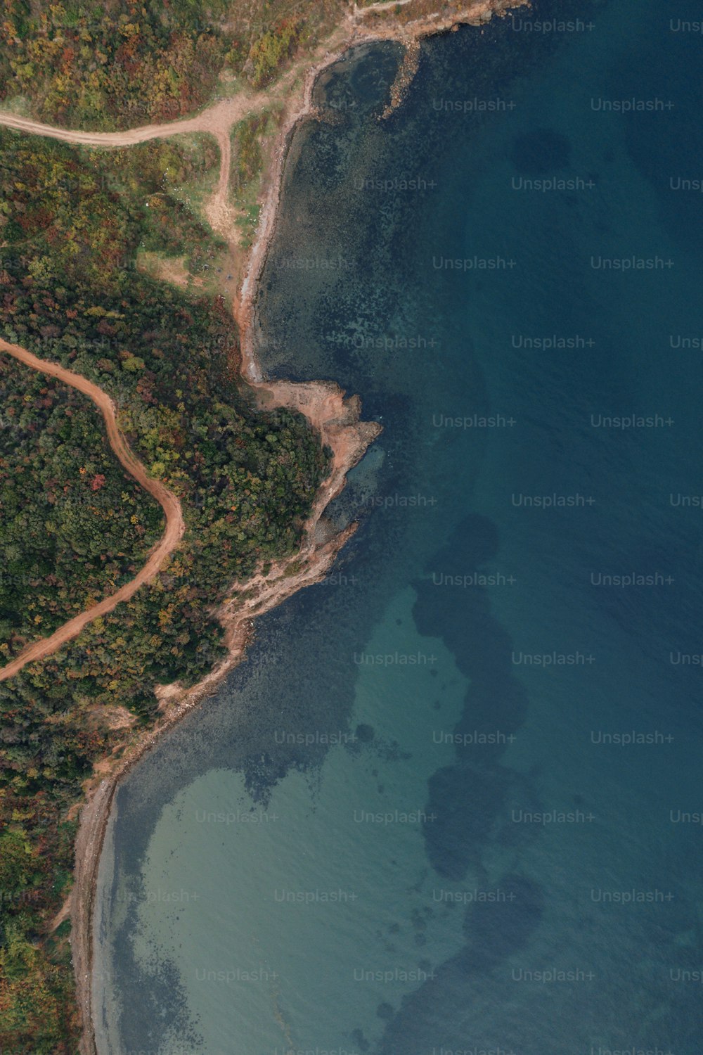 Una vista aérea de una carretera sinuosa junto a un cuerpo de agua