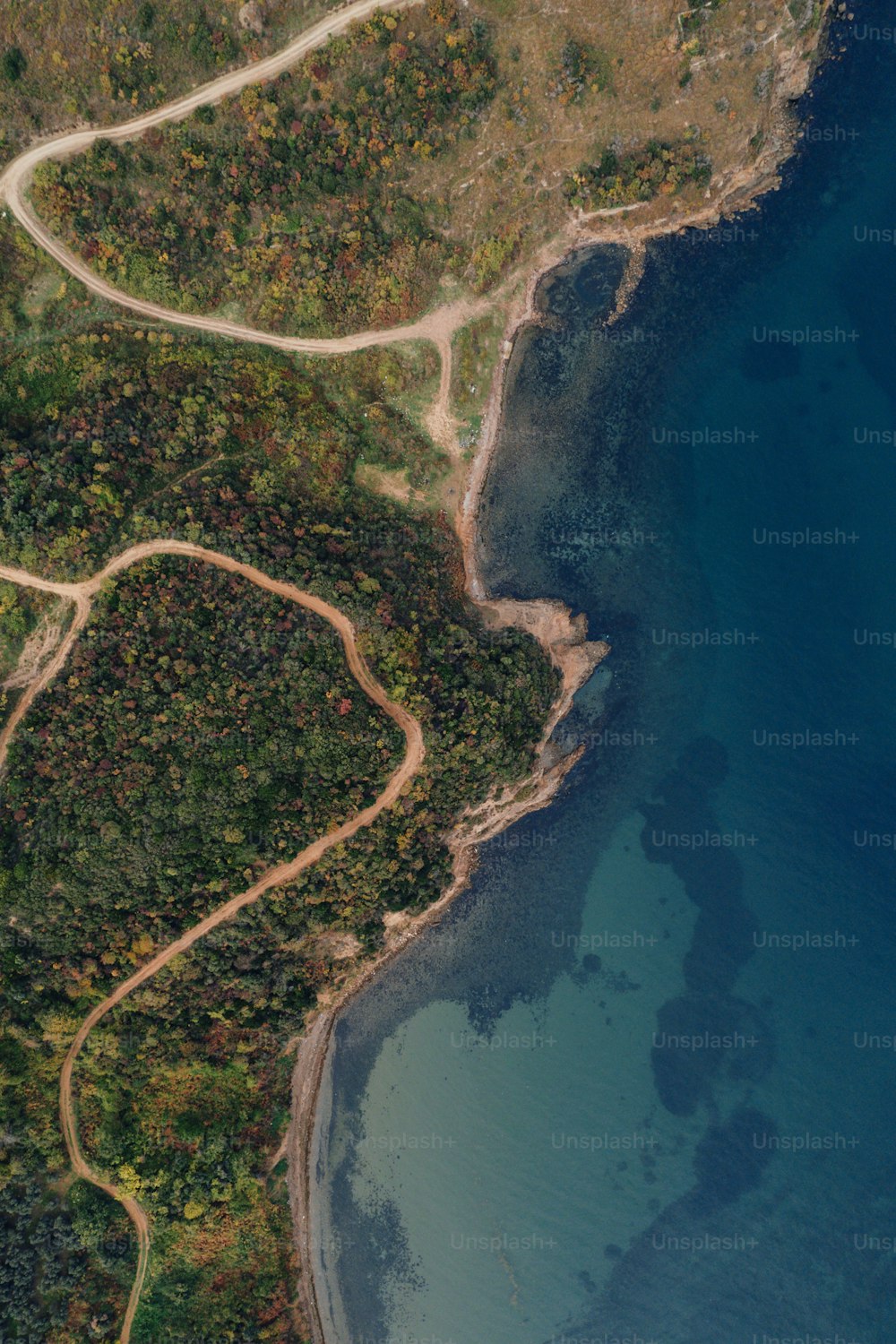 Una vista aérea de una carretera sinuosa junto a un cuerpo de agua