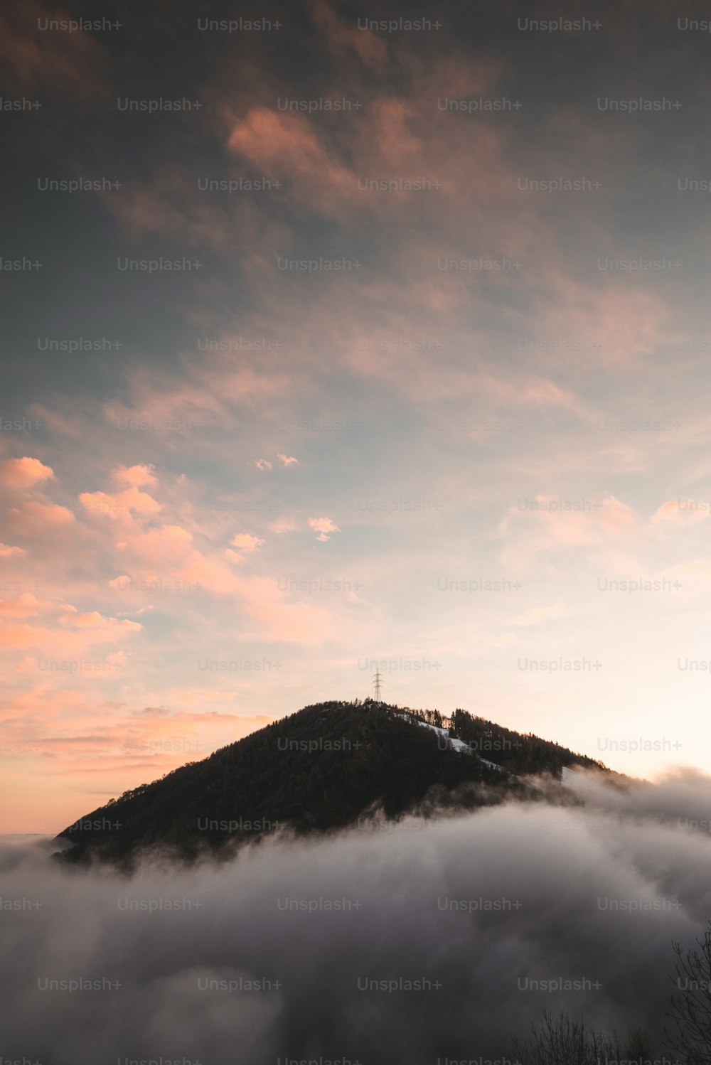 Ein Berg, der bei Sonnenuntergang in Wolken gehüllt ist