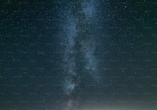 Un gruppo di persone in piedi in cima a un campo sotto un cielo pieno di stelle
