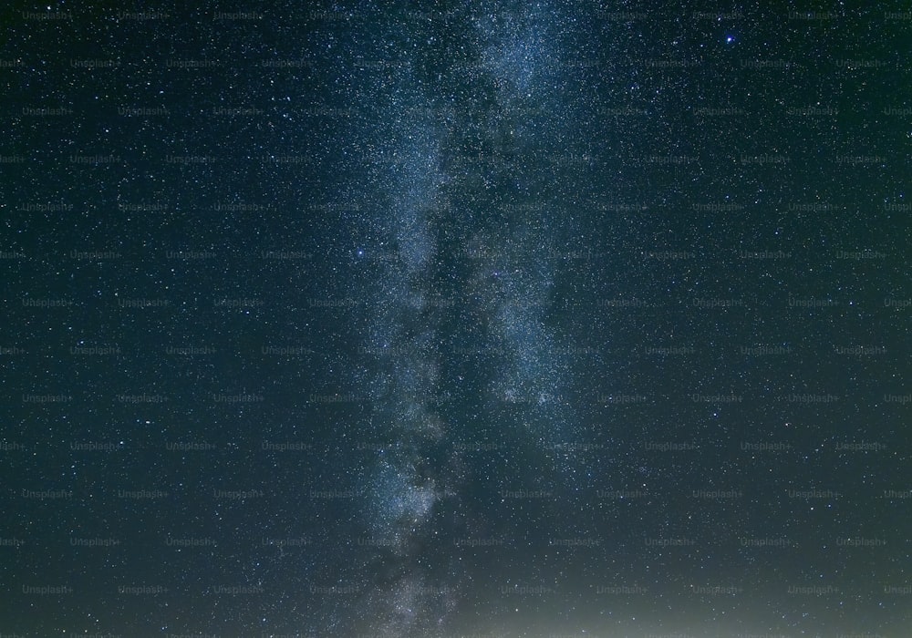 a group of people standing on top of a field under a sky filled with stars