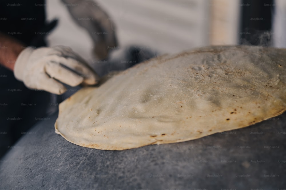 a person is kneading a dough into a ball