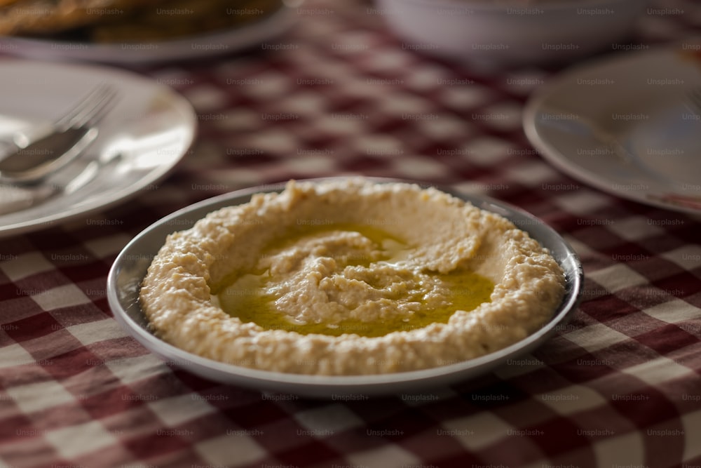 a bowl of hummus sits on a table