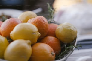 eine Schale mit Orangen und Zitronen auf einem Tisch