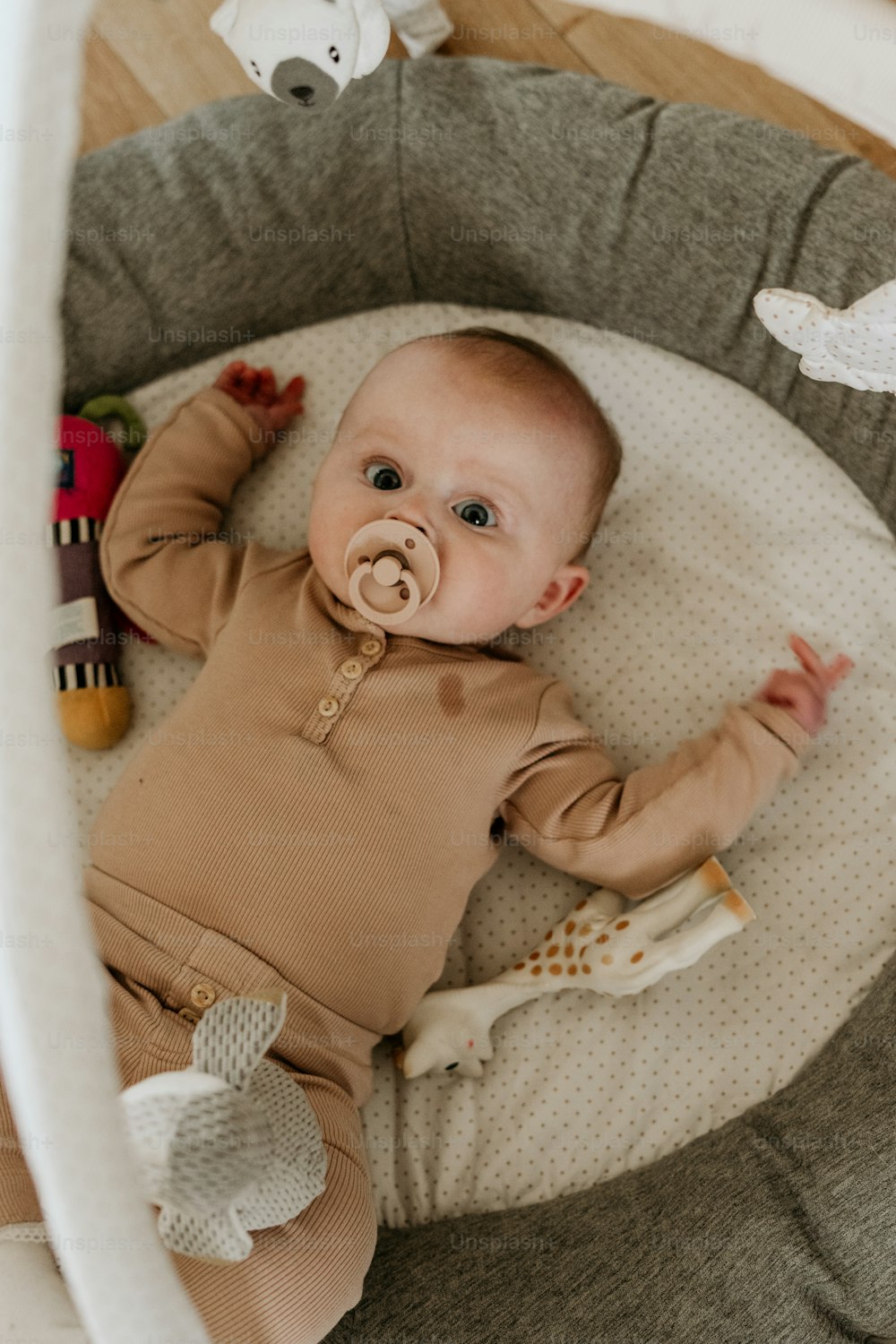Ein Baby, das mit einem Schnuller im Mund in einer Krippe liegt